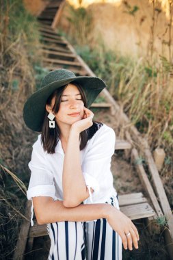 Tropik i üzerinde rahatlatıcı mutlu genç moda kadın Portresi