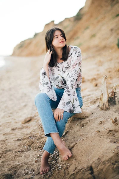 Stylish hipster girl sitting on beach at sea. Happy fashionable — Stock Photo, Image