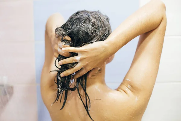 Joven mujer feliz lavándose el cabello con champú, espumoso con ha — Foto de Stock
