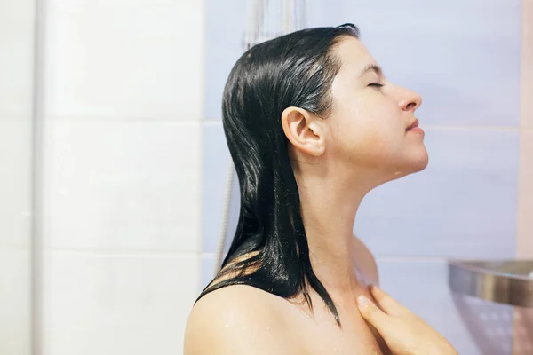 Jeune femme heureuse prenant une douche à la maison ou salle de bain de l'hôtel. Beau. — Photo