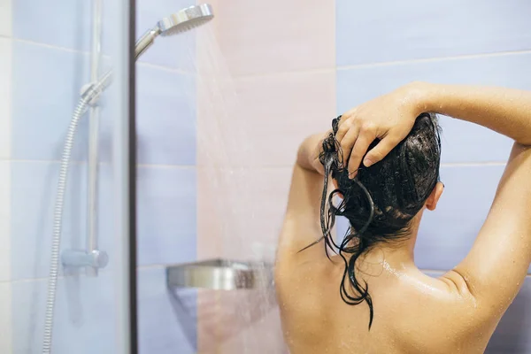Genç ve mutlu bir kadın evde ya da otel banyosunda duş alıyor. Çok güzel. — Stok fotoğraf