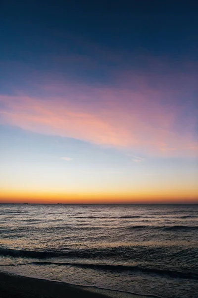 美丽的海浪泡沫特写和粉红色的天空在日出光o — 图库照片