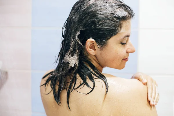 Jong gelukkig vrouw wassen haar haar met shampoo nat haar met f — Stockfoto