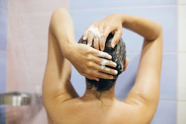 Joven mujer feliz lavándose el cabello con champú, manos con espuma — Foto de Stock