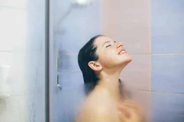 Joven mujer feliz tomando ducha caliente en casa o baño de hotel. S —  Fotos de Stock