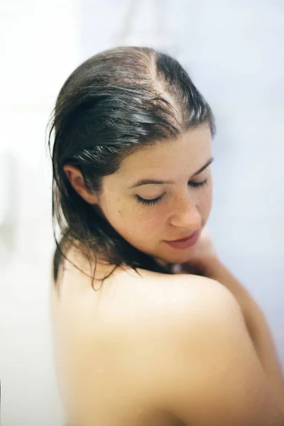 Jeune femme heureuse prenant une douche chaude à la maison ou dans la salle de bain de l'hôtel. B — Photo