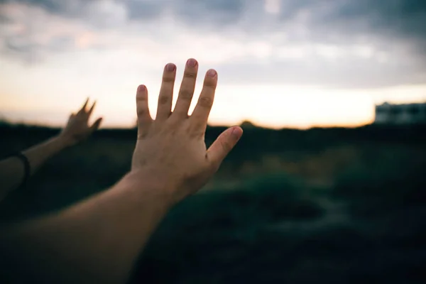 Пара рук на тлі красивої піщаної скелі і заходу сонця — стокове фото