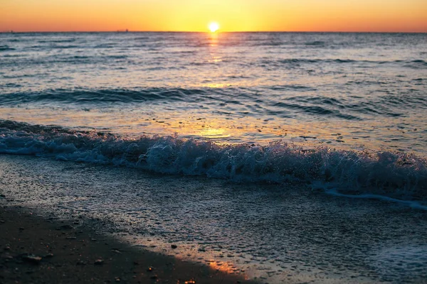 Güzel deniz dalgaları köpük closeup ve gün doğumunda güneş ile kırmızı gökyüzü — Stok fotoğraf
