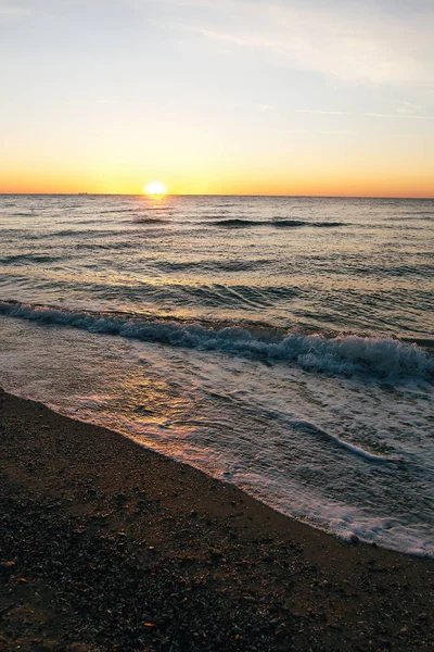 Güzel deniz dalgaları köpük closeup ve gün doğumunda güneş ile kırmızı gökyüzü — Stok fotoğraf