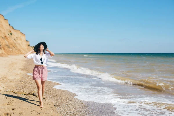 Glückliche junge Boho-Frau, die an sonnigen, warmen Tagen in Meereswellen wandelt — Stockfoto