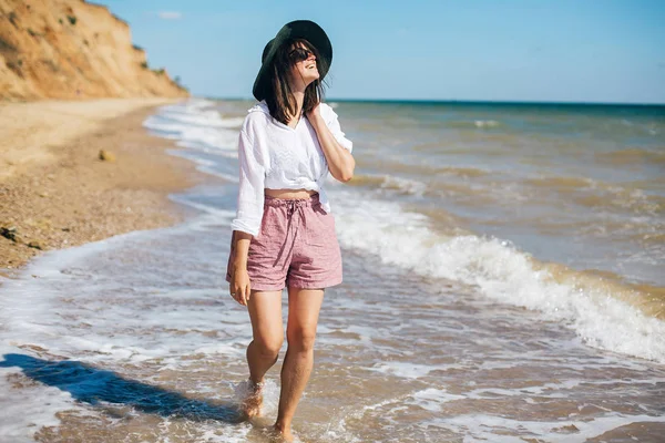 Glücklich junge Boho-Frau zu Fuß und Spaß in Meereswellen in su — Stockfoto