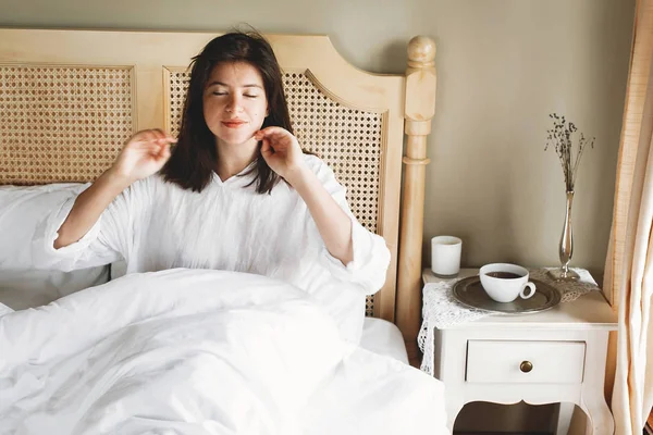 Όμορφη ευτυχισμένη νεαρή γυναίκα που κείτεται στο κρεβάτι το πρωί στο ξενοδοχείο — Φωτογραφία Αρχείου