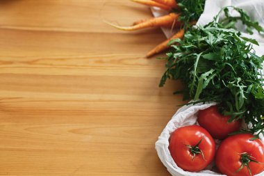 Mutfakta ahşap masada eko pamuk torbalarda taze sebze. 