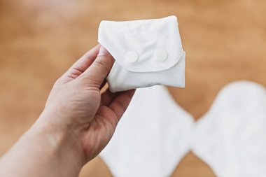 Kadın elinde adet gün için yeniden kullanılabilir eko doğal ped. Beyaz