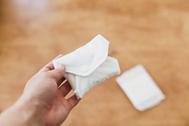 Kadın elinde adet gün için yeniden kullanılabilir eko doğal ped. Beyaz