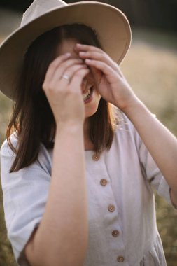 Rustik elbiseli şık kız gülümseyerek ve kır çiçekleri yürüyüş 