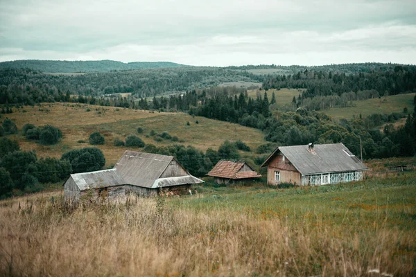 Старые деревянные дома на холмах и солнечные лужи в горах — стоковое фото