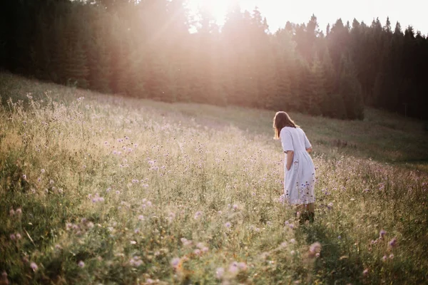 Menina elegante em vestido rústico andando em flores silvestres em mea ensolarada — Fotografia de Stock