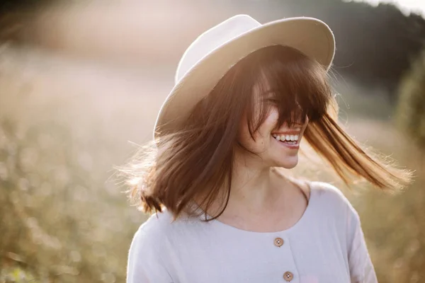 Stilig jente i landlig kjole smiler og vifter med håret i solskinn – stockfoto
