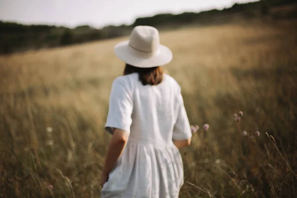 Imagem borrada de menina em vestido de linho correndo entre ervas e wil — Fotografia de Stock