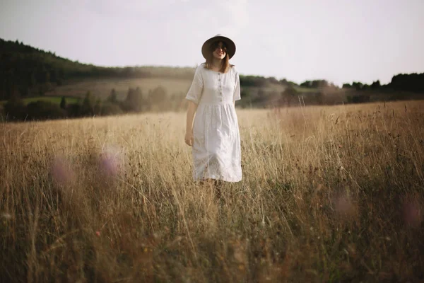 Elegante chica en vestido de lino caminando entre hierbas y flores silvestres — Foto de Stock