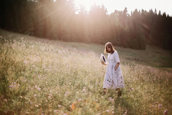 Menina elegante em vestido rústico andando em flores silvestres em mea ensolarada — Fotografia de Stock