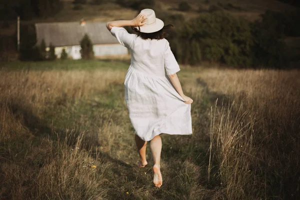 Menina elegante em vestido de linho correndo descalço entre ervas e wil — Fotografia de Stock