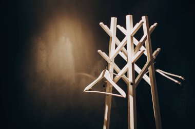 Koyu renkli otel odasında aydınlık şık askı ahşap stand. Modern 