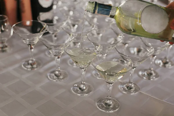 Офіціант наливає мартіні на склянку на столі на весілля — стокове фото