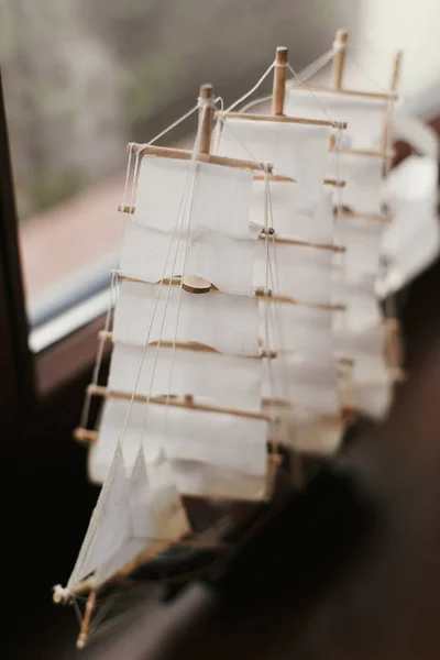 Wooden boat to with sails at window. Little miniature figurine o — Stock Photo, Image