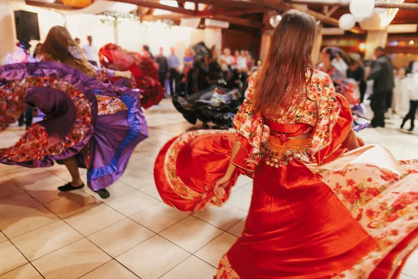 Девушки танцуют в традиционном красном цветочном платье — стоковое фото