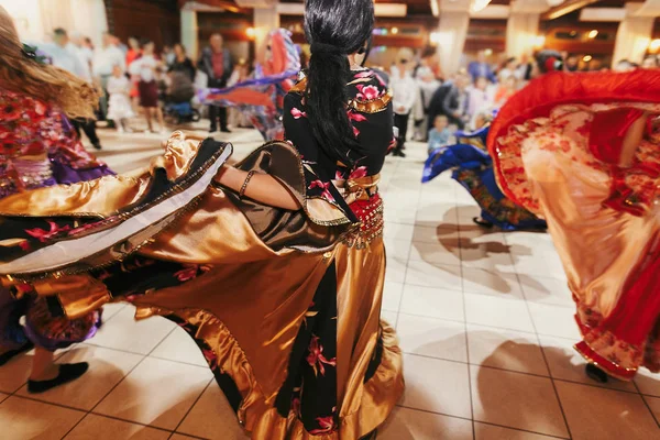 Schöne Zigeunermädchen tanzen in traditioneller bunter Kleidung. — Stockfoto