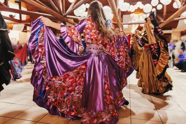 Schöne Zigeunermädchen tanzen in traditionellem lila floralen Kleid — Stockfoto