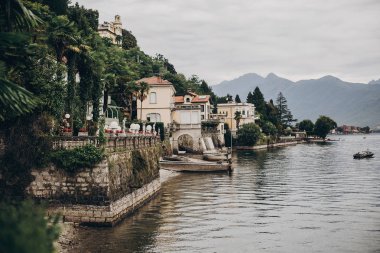 Stresa şehrinde gölde eski binalar ve tekneler üzerinde güzel görünümü