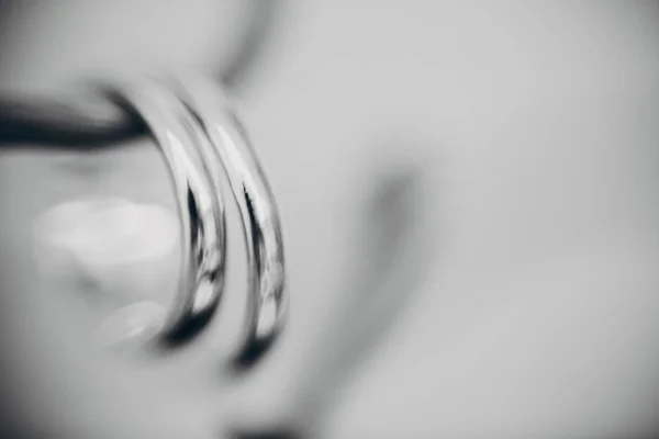 Stock image Stylish silver wedding rings on simple wooden branch, macro blur