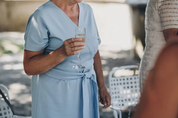 Stylová stará žena držící sklenici šampaňského, opékání a Raisi — Stock fotografie