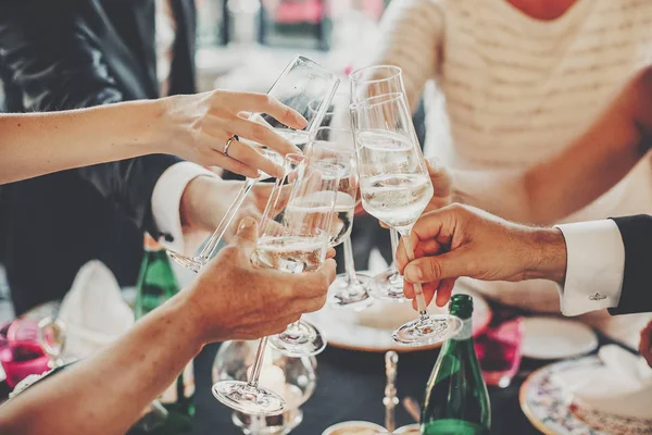 Ruce opékání skleniček šampaňského na svatební hostině — Stock fotografie