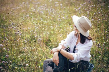 Sırt çantası ile Hipster kız kır çiçeği çayır, seyahat rahatlatıcı