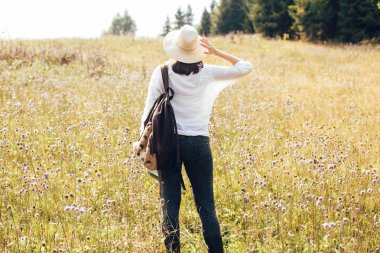 Sırt çantası ile Hipster kız güneşli dağlarda seyahat, yürüyüş