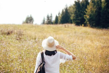 Güneşli dağlarda seyahat sırt çantası ile şık hipster kız.