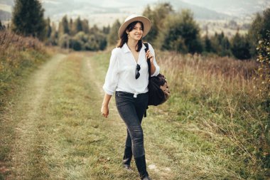 Sırt çantası güneşli binek üstüne seyahat ile Mutlu hipster kız