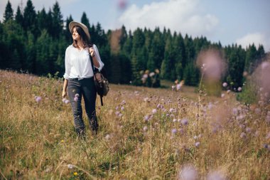 Sırt çantası ile Hipster kız güneşli dağlarda seyahat, yürüyüş