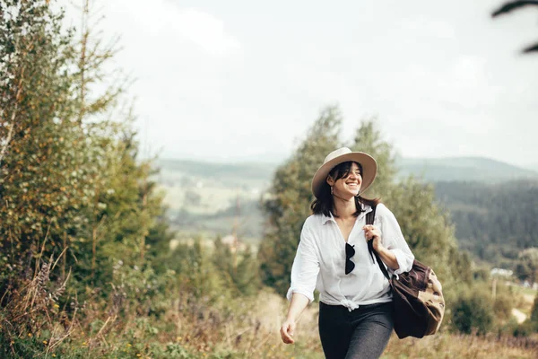 快乐的时髦女孩与背包旅行在阳光明媚的山的顶部 — 图库照片