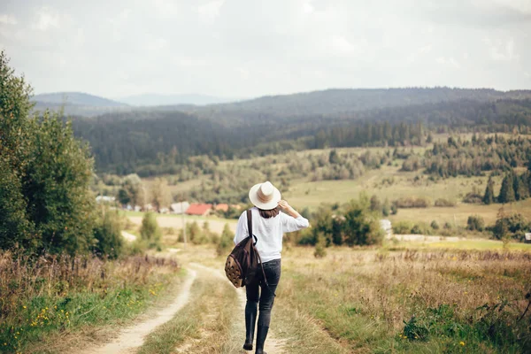 Hipster-Mädchen mit Rucksack unterwegs und zu Fuß auf sonnigem — Stockfoto