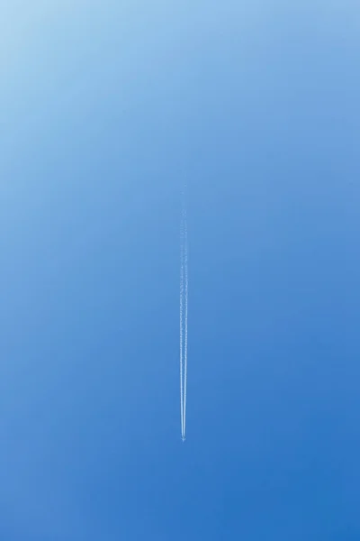 Biały ślad dymu z latającego samolotu. Obraz pionowy. Płaszczyzny — Zdjęcie stockowe