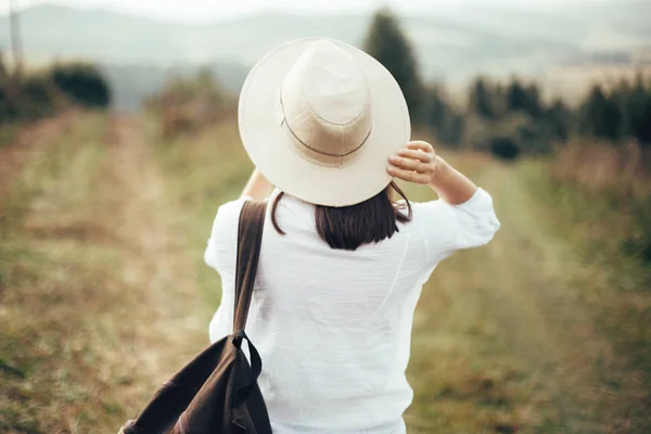 Девушка-хипстер с рюкзаком и шляпой на голове — стоковое фото