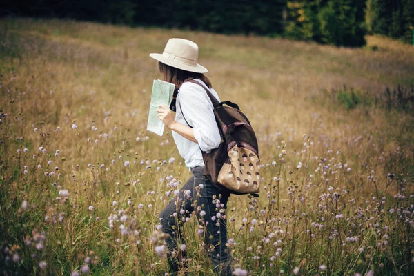 Hipster-Mädchen mit Rucksack und Karte unterwegs in sonnigen Bergen, — Stockfoto