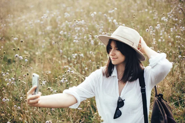 Χίππη κορίτσι με σακίδιο παίρνοντας selfie στο τηλέφωνο ενώ χαλαρώνει — Φωτογραφία Αρχείου