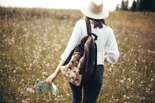 Ragazza hipster con zaino e mappa che viaggia in montagna soleggiata , — Foto Stock