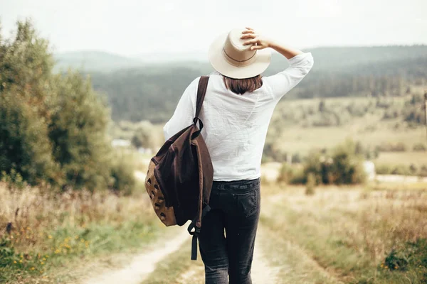 Sırt çantası ile Hipster kız seyahat ve güneşli üstüne yürüme — Stok fotoğraf